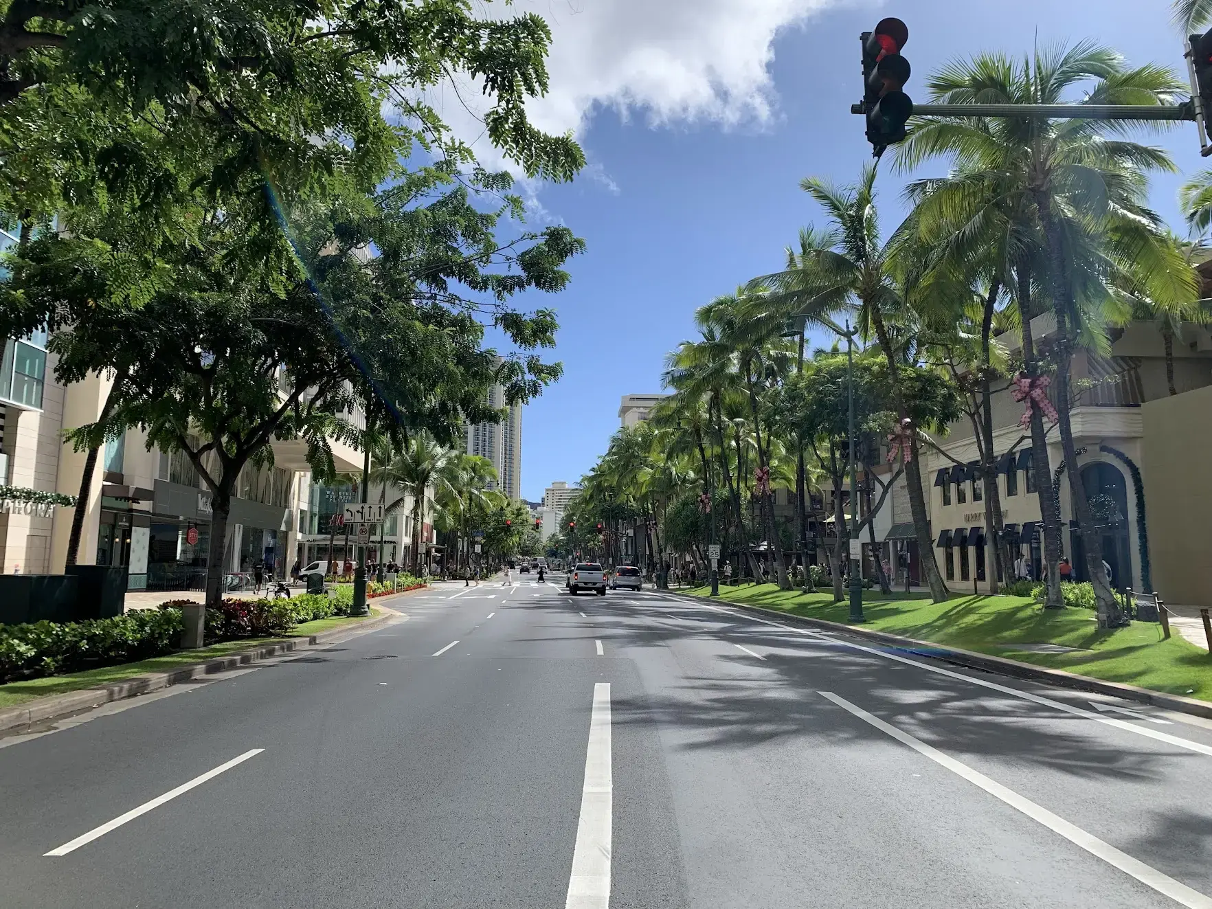 Kalākaua Avenue in Waikiki, with palm trees tied with red Christmas bows