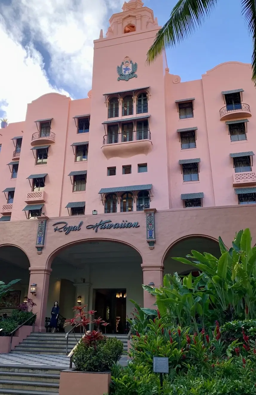 The pink facade and arched entrance of the Royal Hawaiian hotel in Waikiki